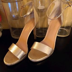 Gold open toe ankle strap heels.